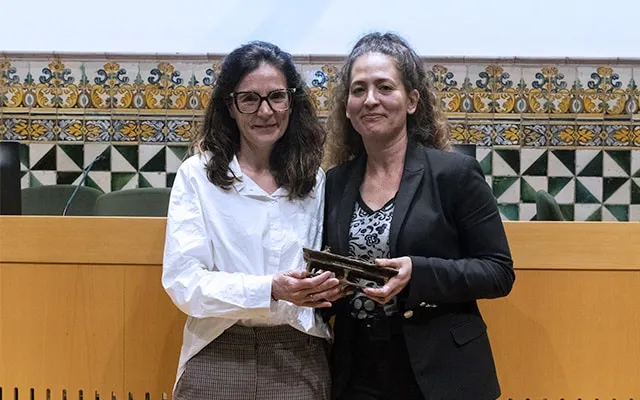 Libertad González and Ada Ferrer-i-Carbonell hold a small statue sculpted in the shape of a table