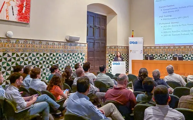 a research presents her work to an auditorium full of colleagues