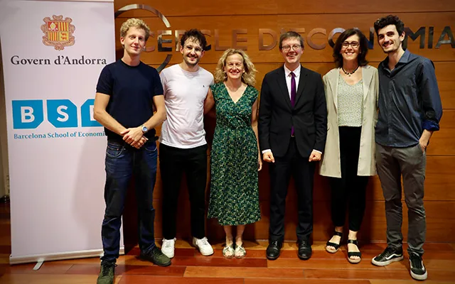 Johannes Stroebel poses with members of Toni Calvó-Armengol's family next to a roll-up with the logos of the Government of Andorra and the Barcelona School of Economics