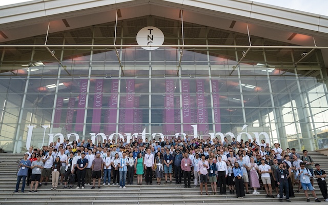 Conference participants post for a group photo on the steps of the National Theater of Catalunya