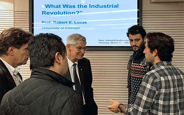 Robert Lucas converses with a group of students and professors
