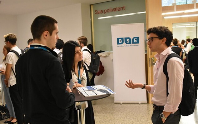 Students talking in bright room at careers fair at Barcelona School of Economics