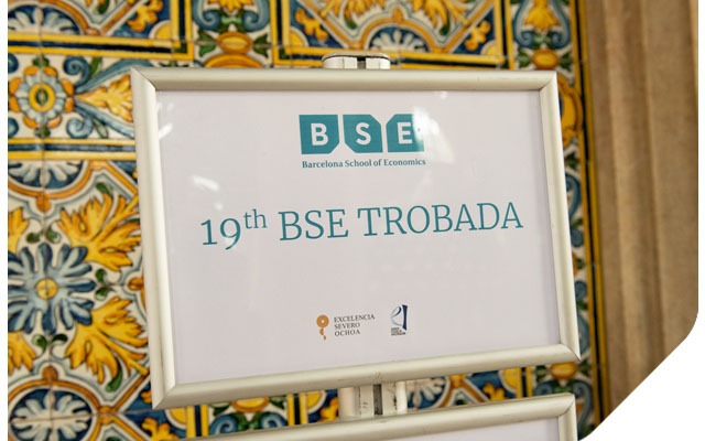 19th Barcelona School of Economics Trobada A sign directing participants next to brightly colored wall tiles