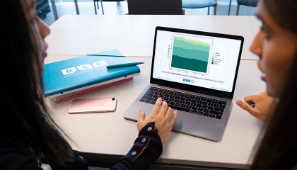 Two students look at slides on a laptop screen