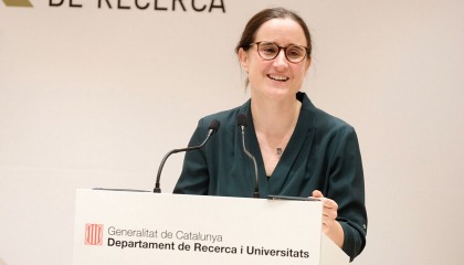Mar Reguant speaks from a lecturn with the logo of the Catalan Ministry of Research and Universities